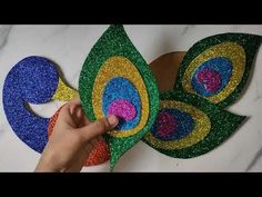 someone is making a peacock decoration out of glitter