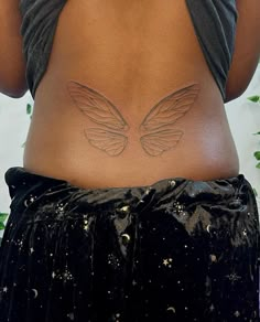 the back of a woman's stomach with angel wings on her lower body and side