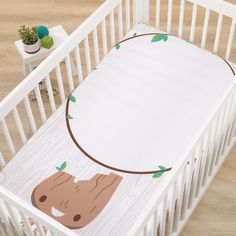 a white crib with a baby's bedding in the shape of a bear