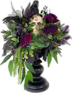 a black vase filled with purple and green flowers