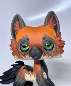 an orange and black figurine with green eyes