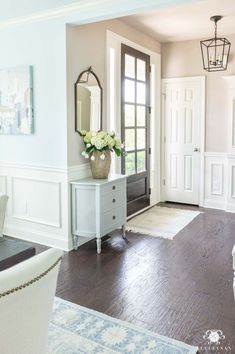 a living room filled with furniture and a large mirror on the wall next to a door