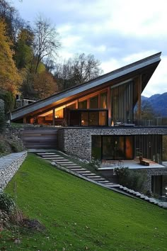 a modern house in the middle of a grassy area with stairs leading up to it