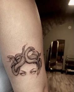 a woman with a snake tattoo on her arm