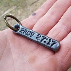 a hand holding a keychain with the word prom written on it