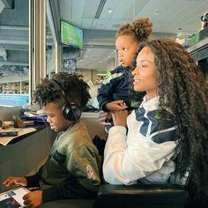 two women and a child sitting in front of computers