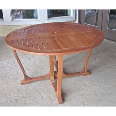 a wooden table sitting on top of a carpeted floor next to an open door