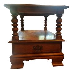 a wooden table with two legs and a drawer on the top, sitting against a white background