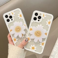 two phone cases with smiley faces and daisies