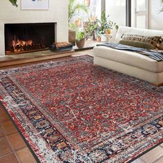 a living room with a large rug on the floor and a fire place in the corner