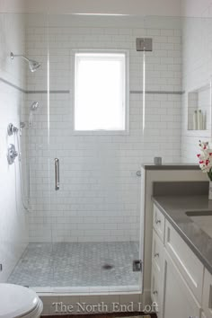 a bathroom with a sink, toilet and shower in it's own area next to a window