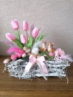 a basket filled with pink flowers on top of a wooden table