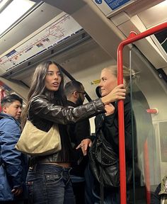 people standing on a subway train with their backs to each other as they look at something