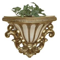 a gold planter with ivy growing out of it's top and leaves on the bottom