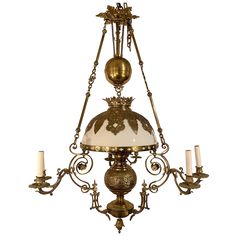 an antique chandelier with five candles and a glass shade hanging from the ceiling