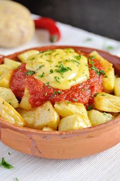 a bowl filled with potatoes covered in marinara sauce