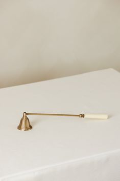 a white table topped with a brass bell