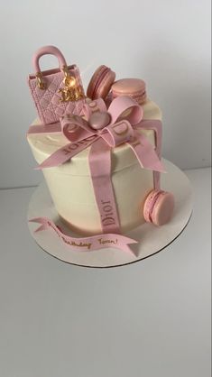 a birthday cake decorated with pink and gold decorations on top of a white platter