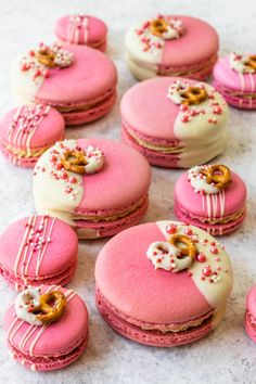 pink macaroons with white and gold decorations on them