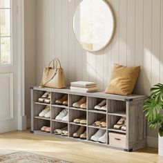 a wooden shoe rack filled with shoes next to a potted plant and a round mirror