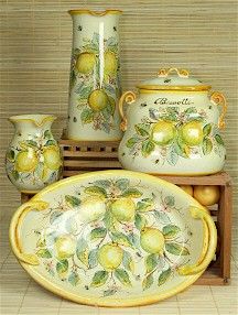 an assortment of lemons and limes painted on ceramic dishes with matching vases