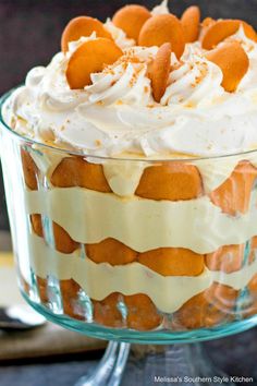 a cake with white frosting and orange peels on top in a glass dish