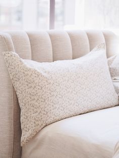 a couch with two pillows on it and a window in the backgroung