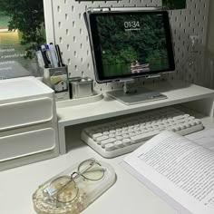 a computer monitor sitting on top of a white desk next to a keyboard and mouse