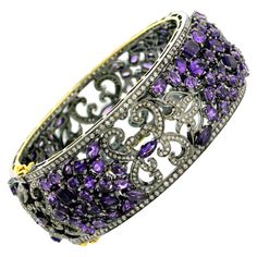 This Diamond Amethyst Designer Mosaic Bangle Bracelet in Silver and 18K Gold is pretty and wraps around the wrist very nicely. This bangle opens on side and has box clasp. 18kt gold:6.2gms Diamond:5.1cts Silver:44.15gms Amethyst:27.02cts Amethyst Bangle, Fancy Sapphire, Vintage Bangle Bracelets, Bangle Silver, Bracelet In Silver, Vintage Bangles, Box Clasp, Silver Bangle Bracelets, Women Diamond