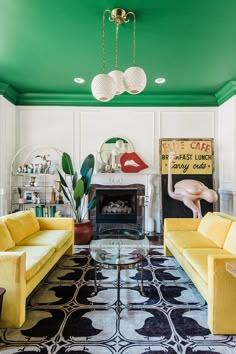 a living room with yellow couches and green painted walls in an eclectic style home