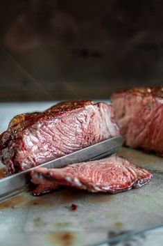 two steaks on a cutting board with a knife