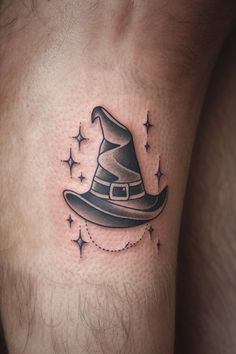 a man's leg with a wizard hat tattoo on the thigh and stars around it