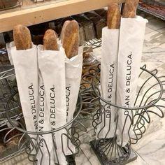 four baguettes sitting on top of a metal rack next to each other in a store