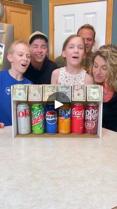 a group of people standing in front of a counter with cans and money on it