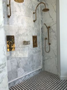 a bathroom with black and white checkered flooring, gold fixtures and marble walls