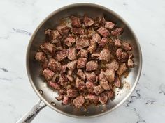 a pan filled with meat on top of a white counter