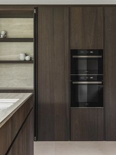 a kitchen with dark wood cabinets and white counter tops