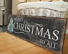 a merry christmas to all sign sitting on top of a wooden table next to a chair