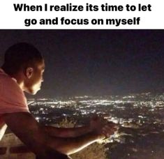 a man sitting on top of a building at night