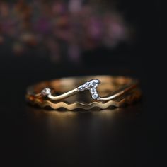 a gold ring with two diamonds on it