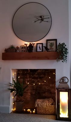 a fireplace with candles and pictures on the mantel above it, next to a mirror