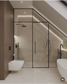 a bathroom with a toilet, tub and shower in it's center wall is illuminated by recessed lighting