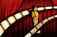 an oscar statue sitting on top of a black pedestal in front of a red curtain