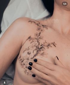 a woman's breast with flowers and leaves on her chest, showing the tattoo