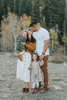 a family poses for a photo in the woods