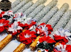 red and white flowers are on sticks with silver sequins in the back ground