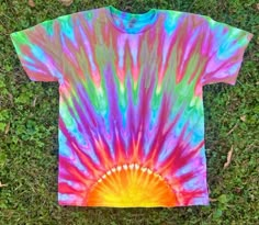 a tie - dyed shirt laying on the grass