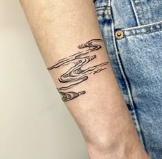 a woman's arm with a tattoo on it that has waves coming out of the water