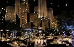 a large room filled with lots of tables covered in white clothed cloths and chandeliers