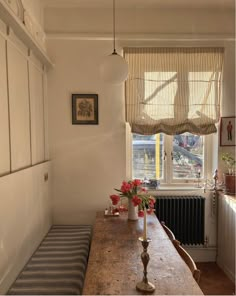 a wooden table sitting next to a window in a room with a radiator